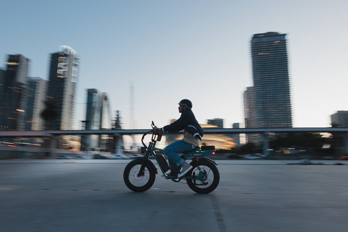 RetroVolt Max electric bike ridden through a city skyline at dusk