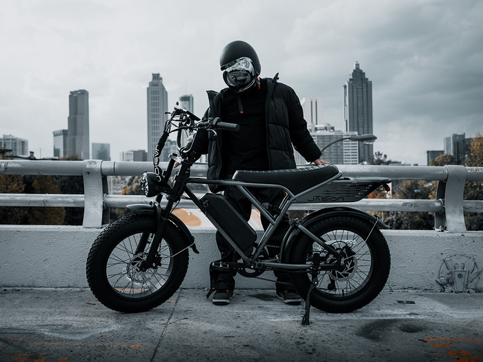 Rider standing with JasionBike RetroVolt Pro electric bike in an urban scene